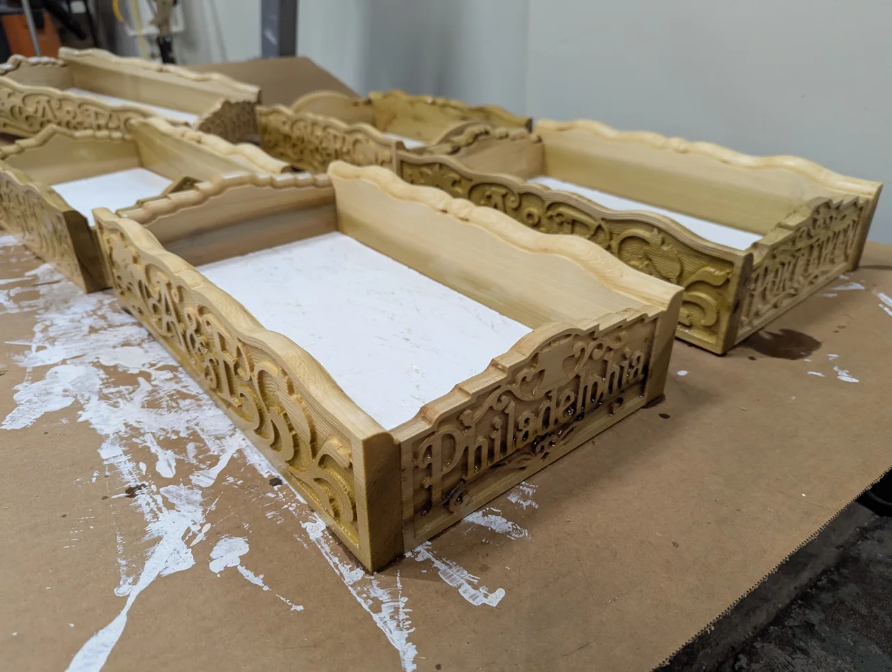 Custom monograms and decorative carved wood panels assembled into centerpiece boxes
